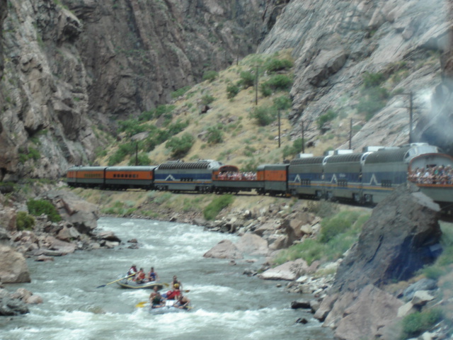 Royal Gorge Route train running beside rafters on the Arkansas River